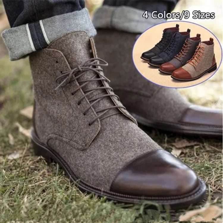 Men's black leather motorcycle ankle boots with side belt buckles and a thick rubber sole on a wooden floor.