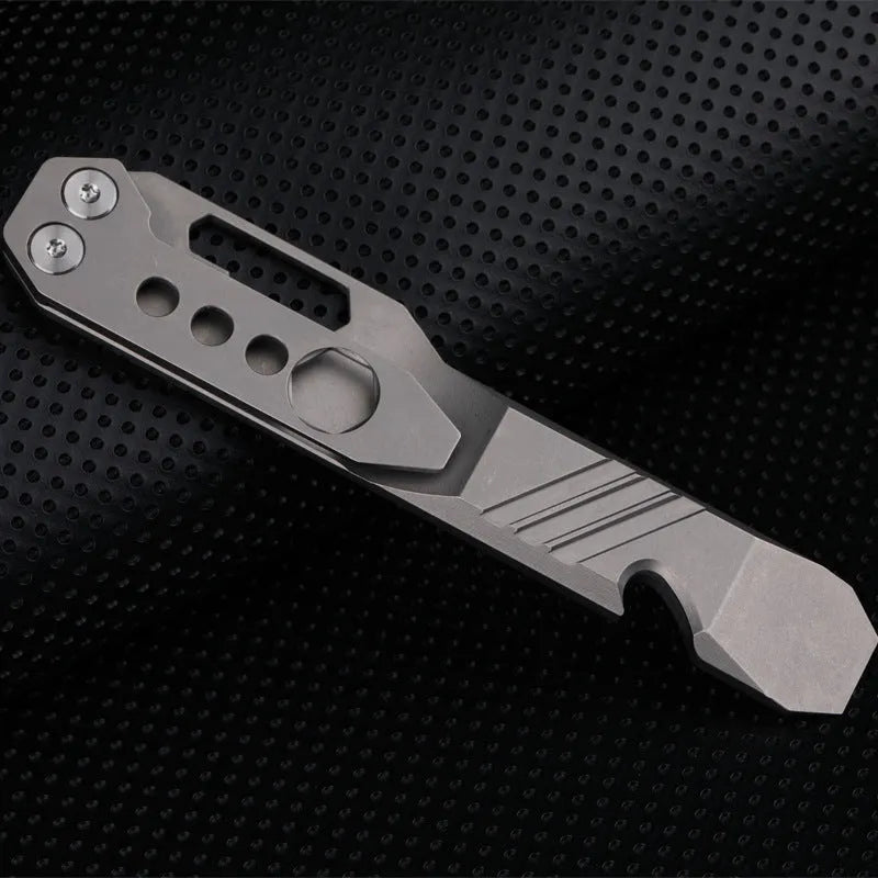 Titanium alloy multi-tool with crowbar edge, screwdriver tip, and bottle opener notches on a stone wash finish background.