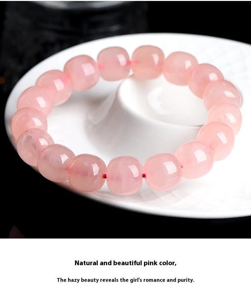 Close-up of a pink natural crystal bracelet with polished barrel-shaped beads measuring 8-10mm.