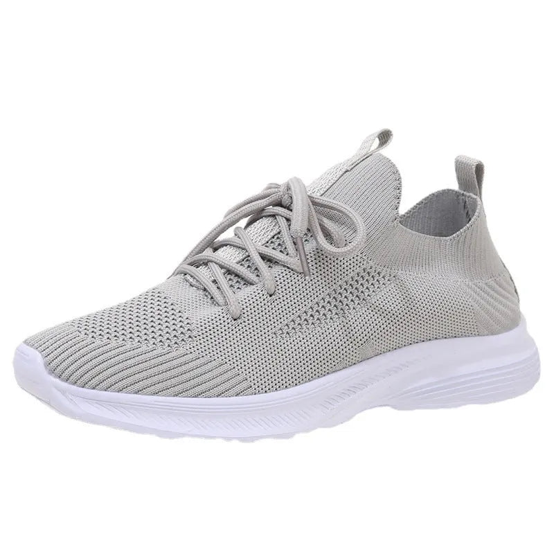 Women's low-top mesh running shoes in creamy white with a Flyknit upper and flat rubber sole.