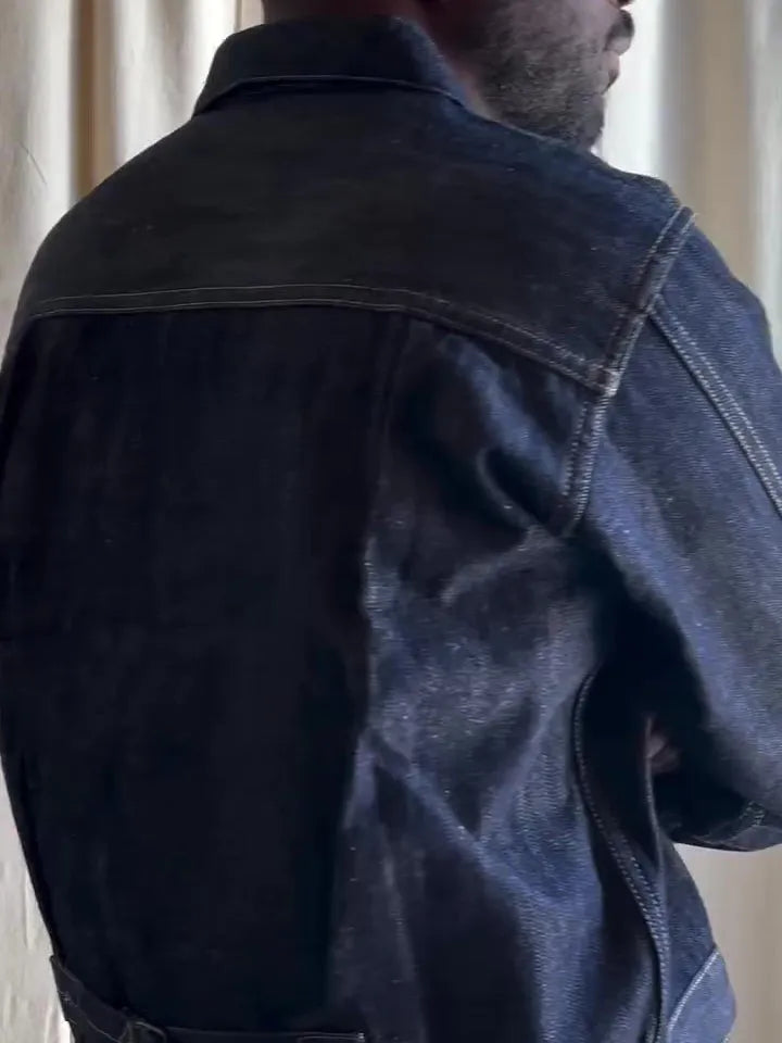 Dark blue denim button-up jacket with classic collar on a standard hanger
