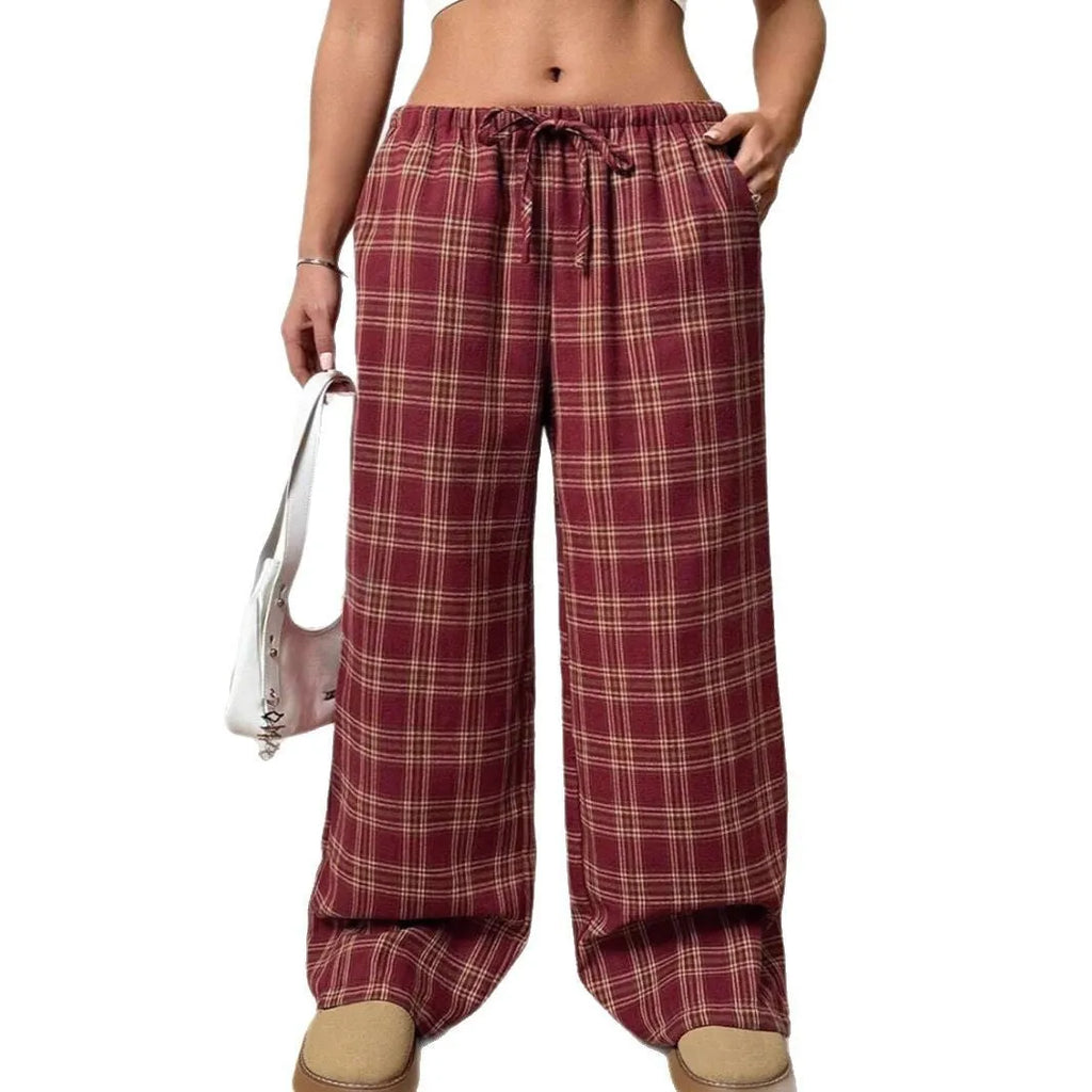 Red plaid women's casual trousers with a drawstring waist and pockets on a hanger.