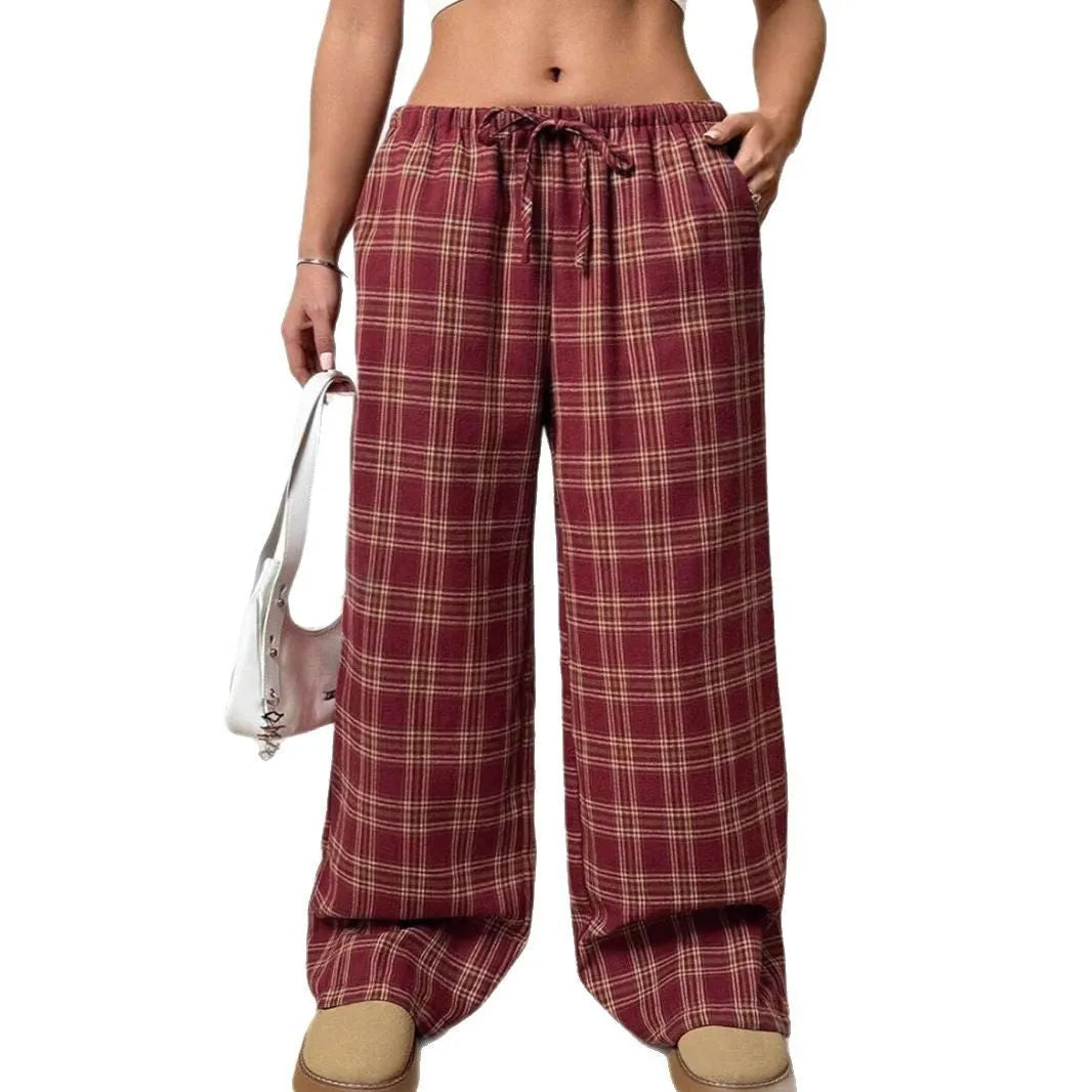 Red plaid women's casual trousers with a drawstring waist and pockets on a hanger.