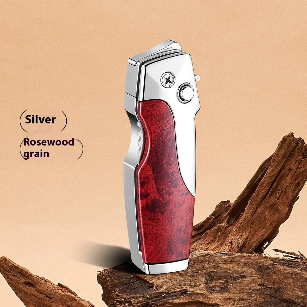 Closed metal folding lighter with integrated knife in a carbon fibre finish, showing the safety lock and refill valve.