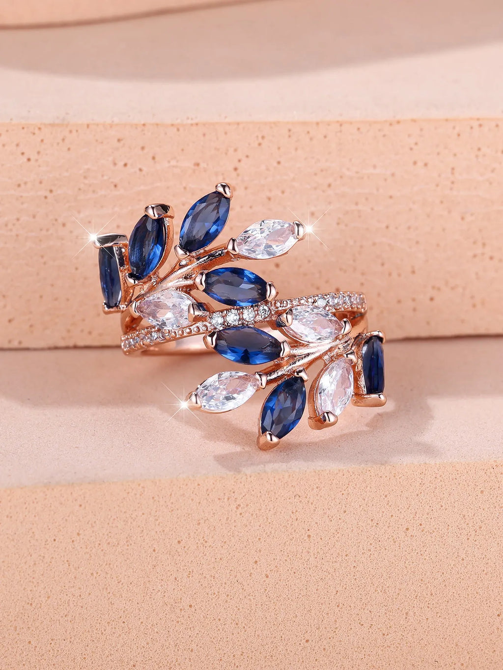 Adjustable copper leaf ring with a central zircon stone on a finger, showing rose gold and platinum colour options.