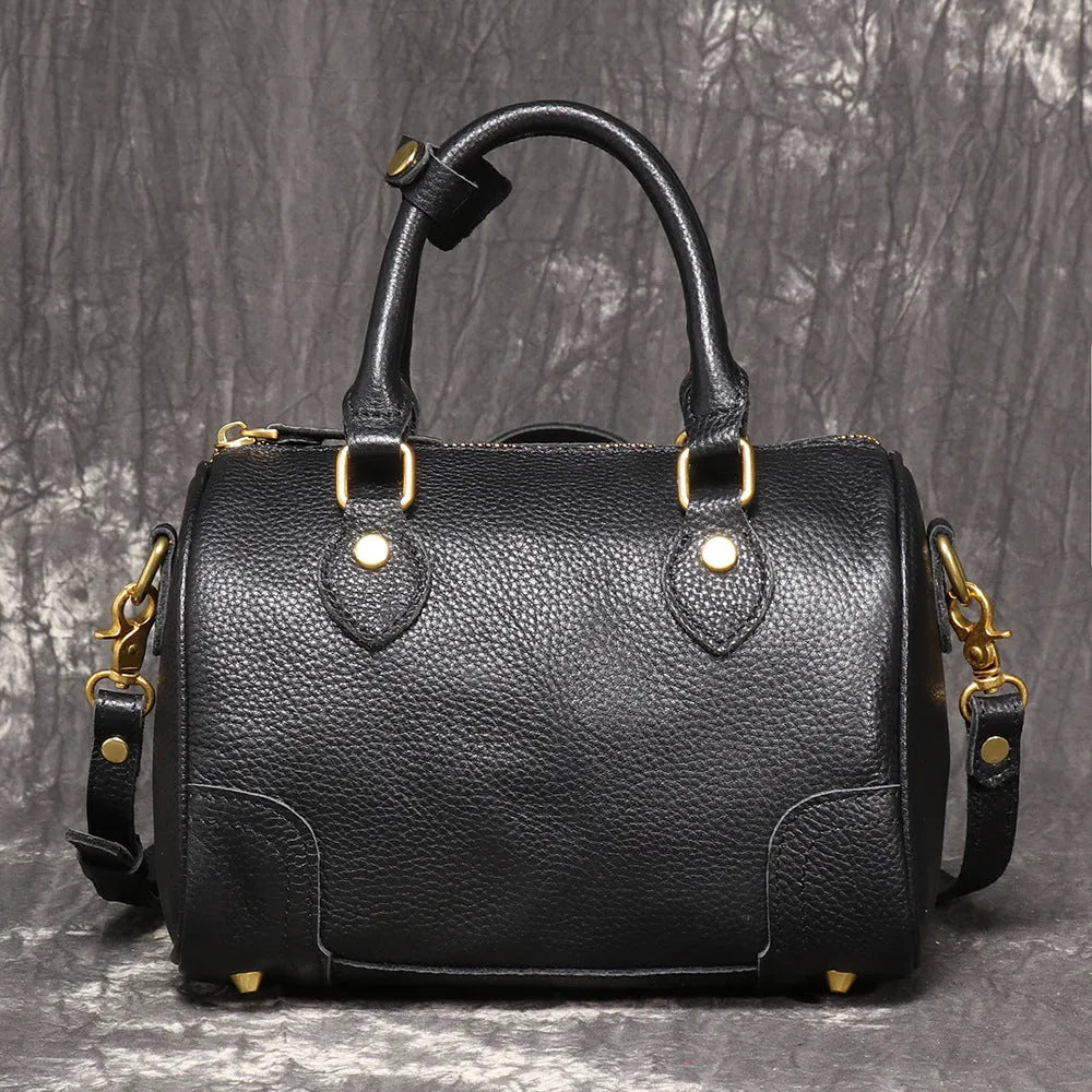 Brown yellow cowhide leather Boston bag with single shoulder strap, showing cylindrical shape and open outer pocket.