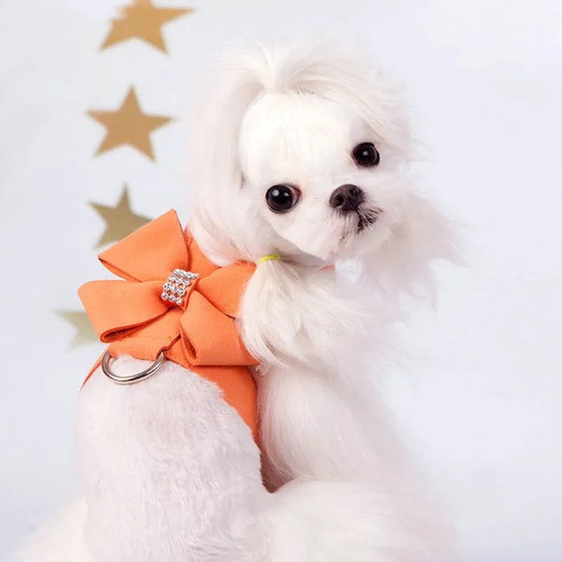 A pink microfiber dog chest strap with a white bowknot, showing the adjustable size buckles.