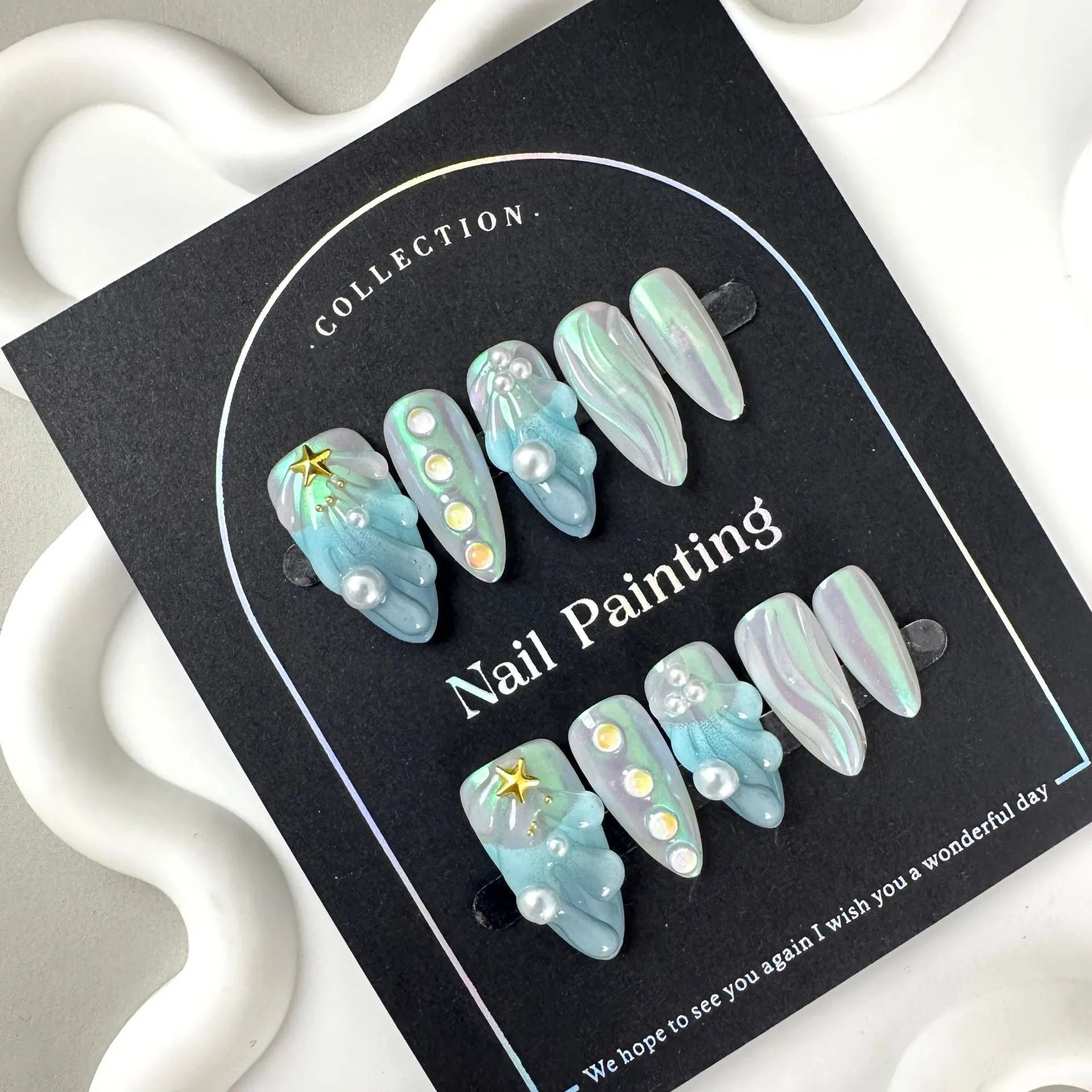Set of blue plastic shell-shaped nail stickers in sizes XS, S, M, and L