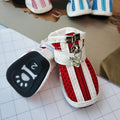 Four pairs of blue, pink, and red cloth dog shoes with zip fastenings on a white background.