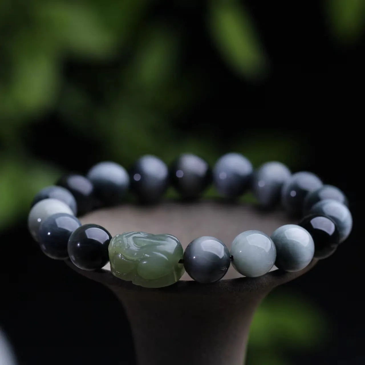 Black 10mm Eagle Eye Stone bracelet with a natural Hetian Jade Pixiu charm showing a clear water pattern.
