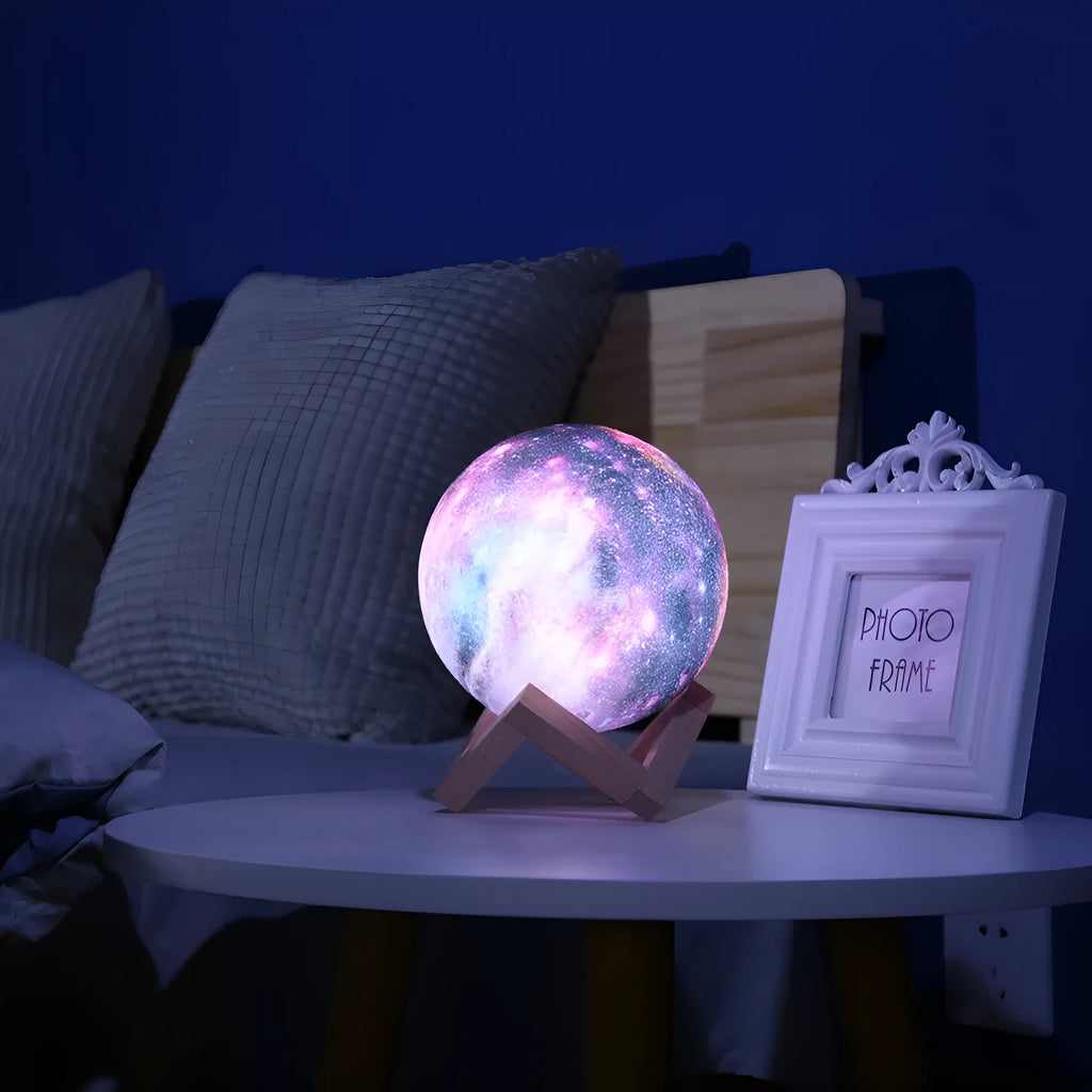 3D-printed spherical moon night light glowing with colour-changing LEDs on a dark surface.