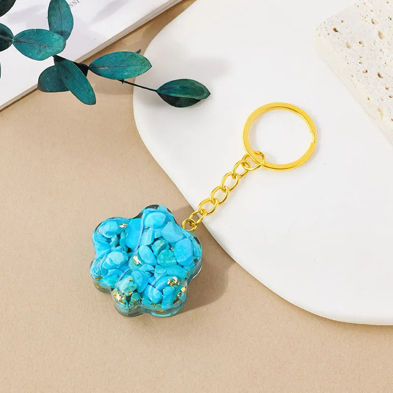 Hand-finished natural crystal cat's paw keychain pendant on a metal ring, showing detailed carving and polished stone surface.