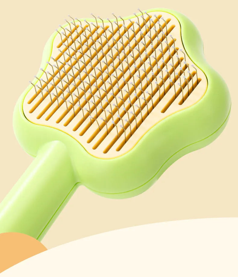 Green self-cleaning pet comb with stainless steel needles on a white background.