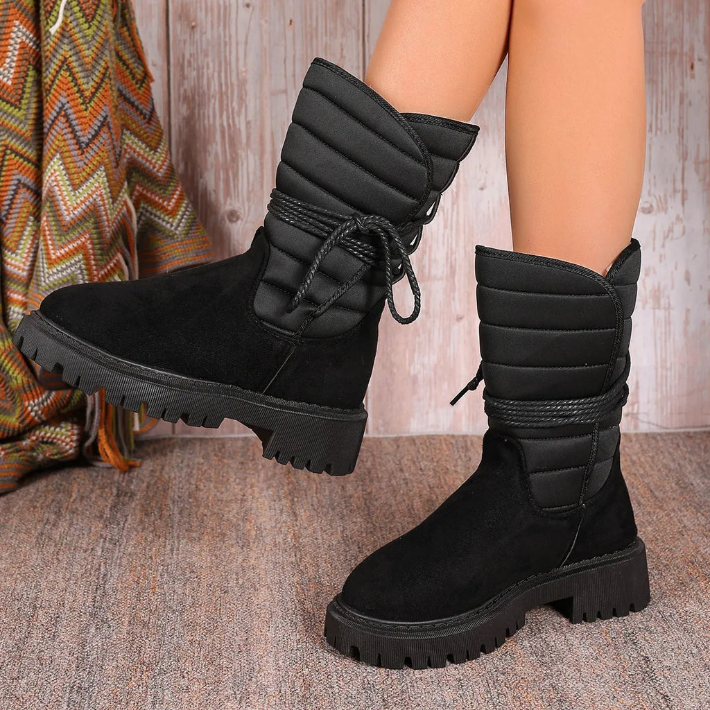 Women's black chunky heel snow boots with lace-up design and fleece lining on a high-top suede upper.
