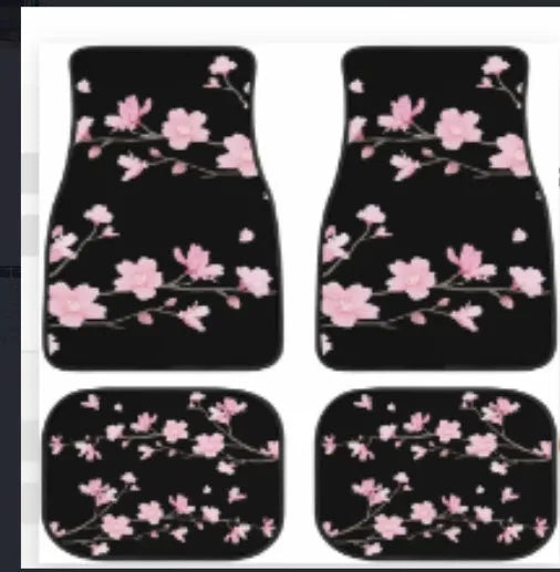 Set of four black rubber car floor mats with a textured surface and raised edges, shown in a vehicle footwell.