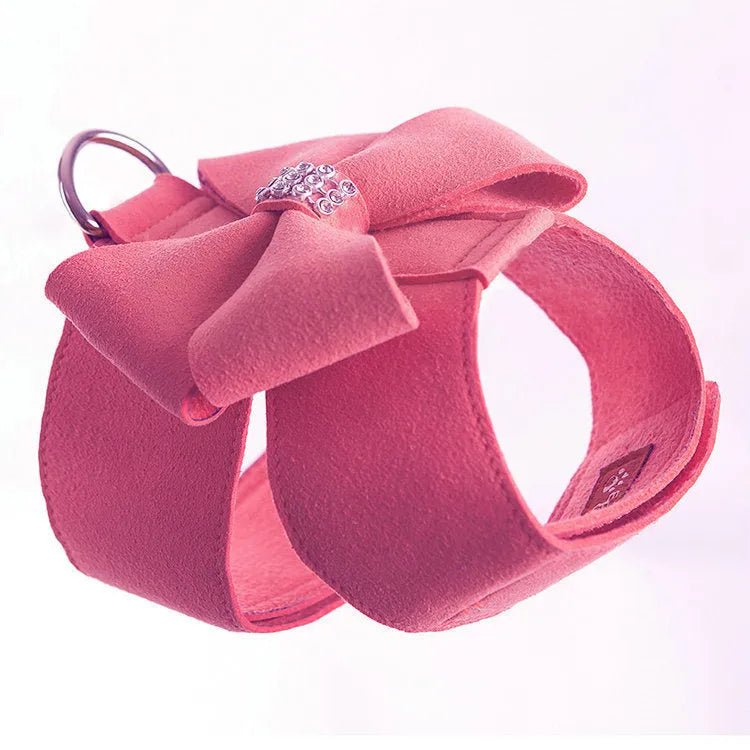 A pink microfiber dog chest strap with a white bowknot, showing the adjustable size buckles.