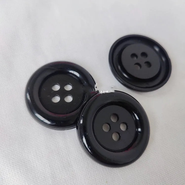 Oversized round edge plastic button with four holes in various colours and diameter sizes