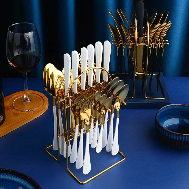 24-piece stainless steel cutlery set with knives, forks, spoons and teaspoons on a storage rack.