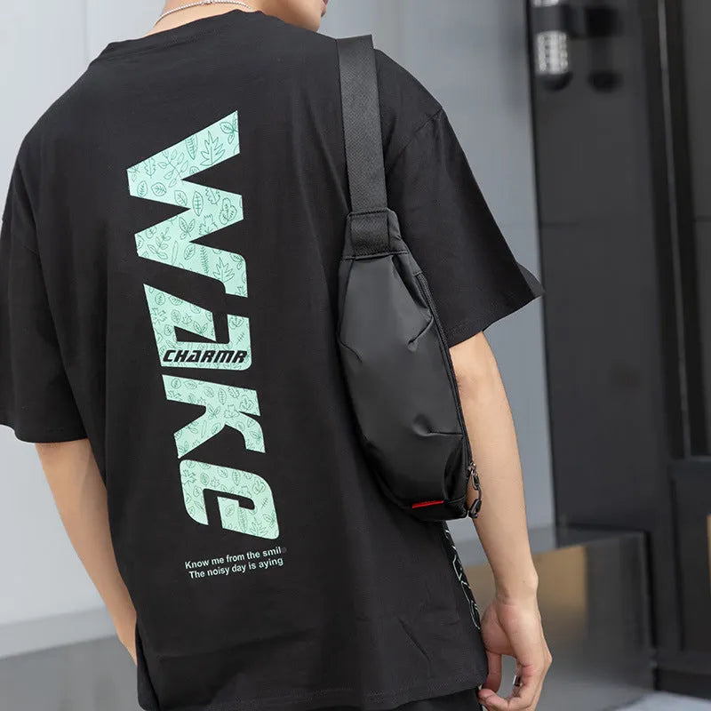 Black Oxford cloth men's crossbody waist pack showing front zipper and strap.