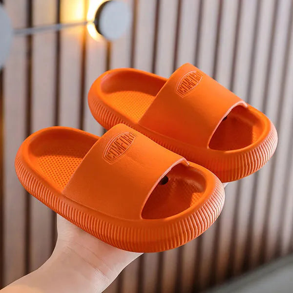 Colourful children's EVA slippers with textured sole, shown in blue, green, orange, pink, and yellow.