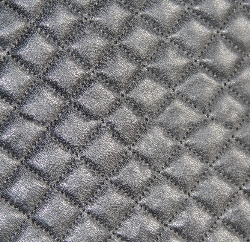 Black quilted automotive seat cover made of PU and polyester fabric on a car seat.