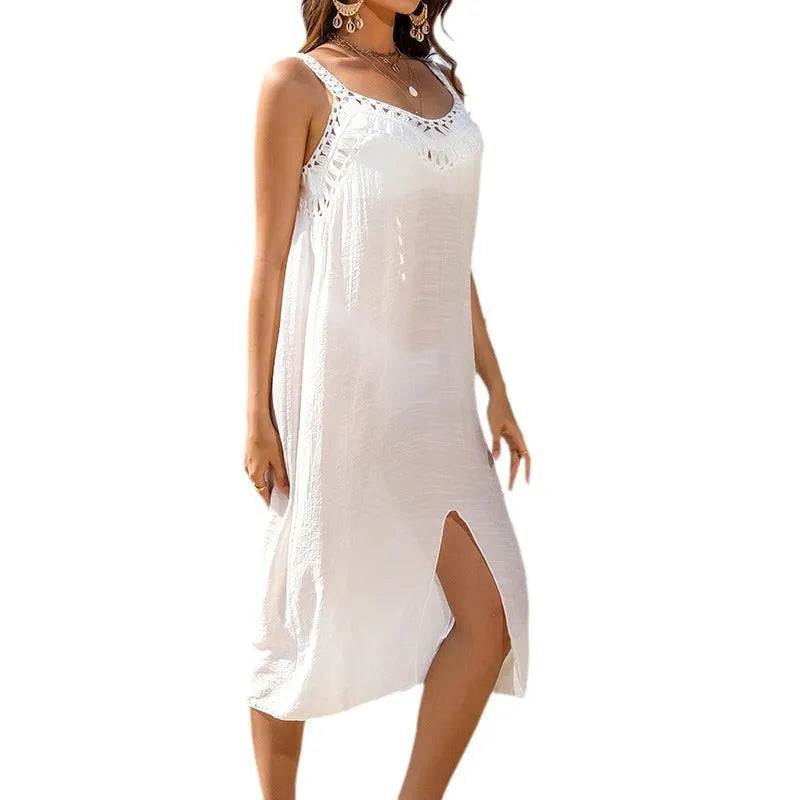White women's suspender beach dress with hollow crochet pattern and a bottom slit.