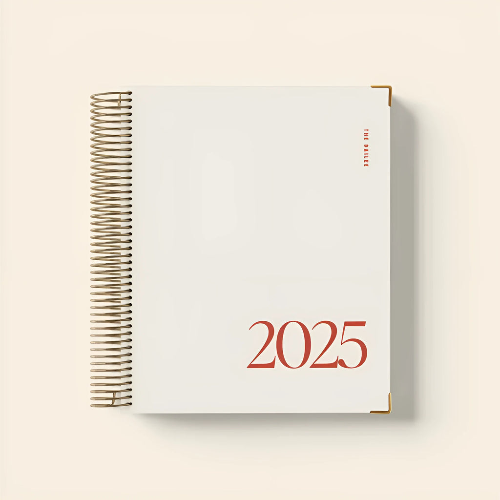 Cherry red A4 spiral coil notebook open on a desk, showing flat-lying pages.