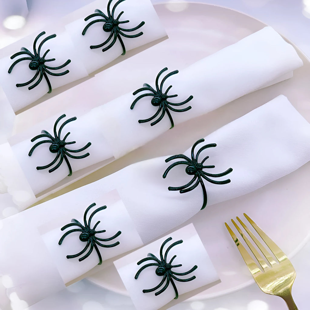 Set of six black alloy napkin rings with detailed spider sculpture for Halloween table decor.