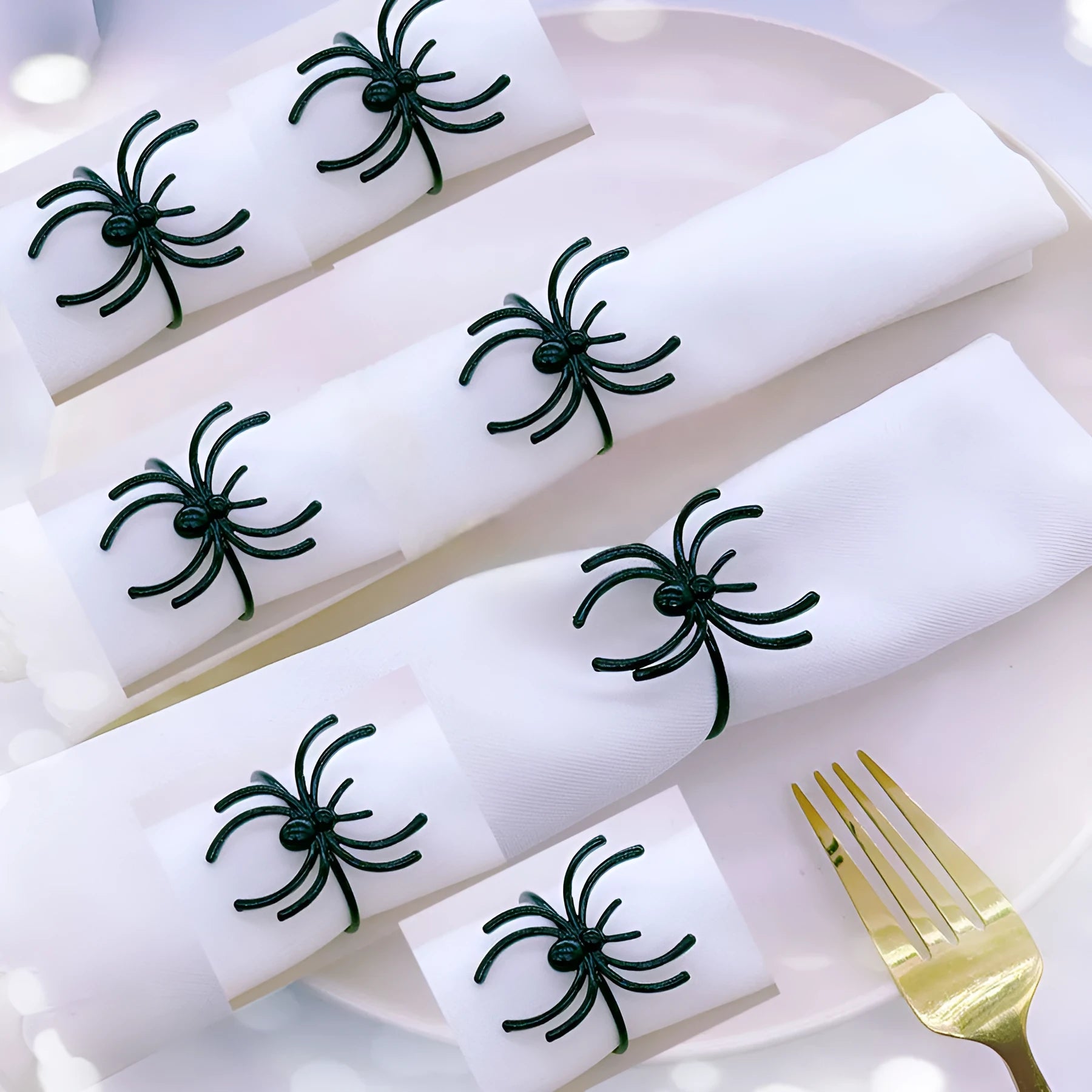 Set of six black alloy napkin rings with detailed spider sculpture for Halloween table decor.