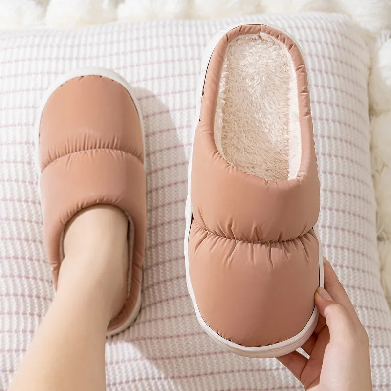 Blue down cotton winter slippers with a thick rubber sole and plush lining, shown on a wooden floor.