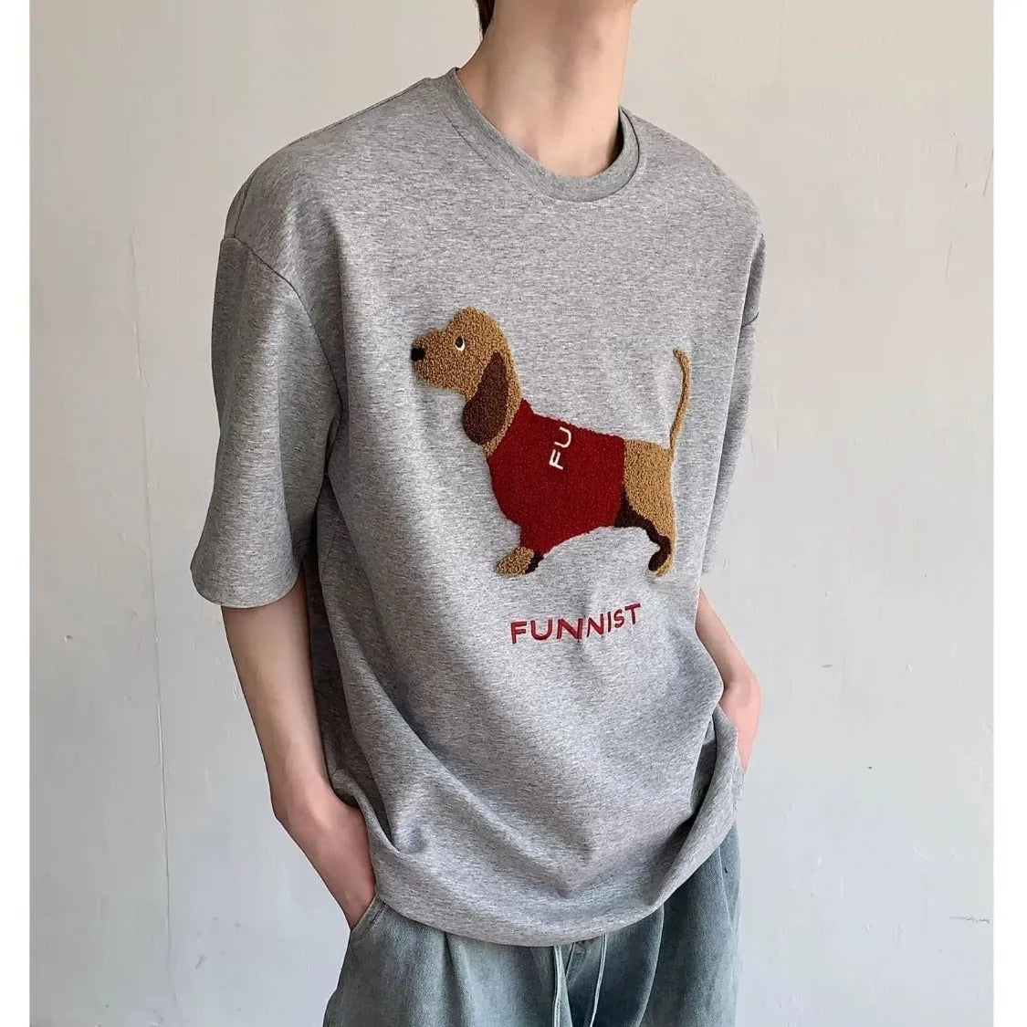 Men's gray cotton t-shirt with an embroidered cartoon sausage dog holding a blue towel.