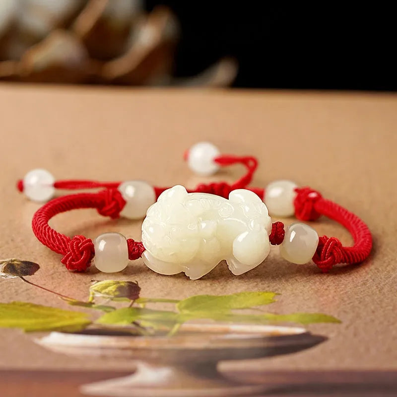 Close-up of a brown and black braided rope bracelet with a central Hetian jade bead on a wrist.