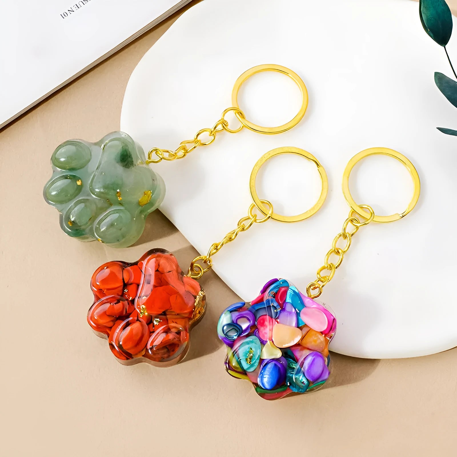 Hand-finished natural crystal cat's paw keychain pendant on a metal ring, showing detailed carving and polished stone surface.