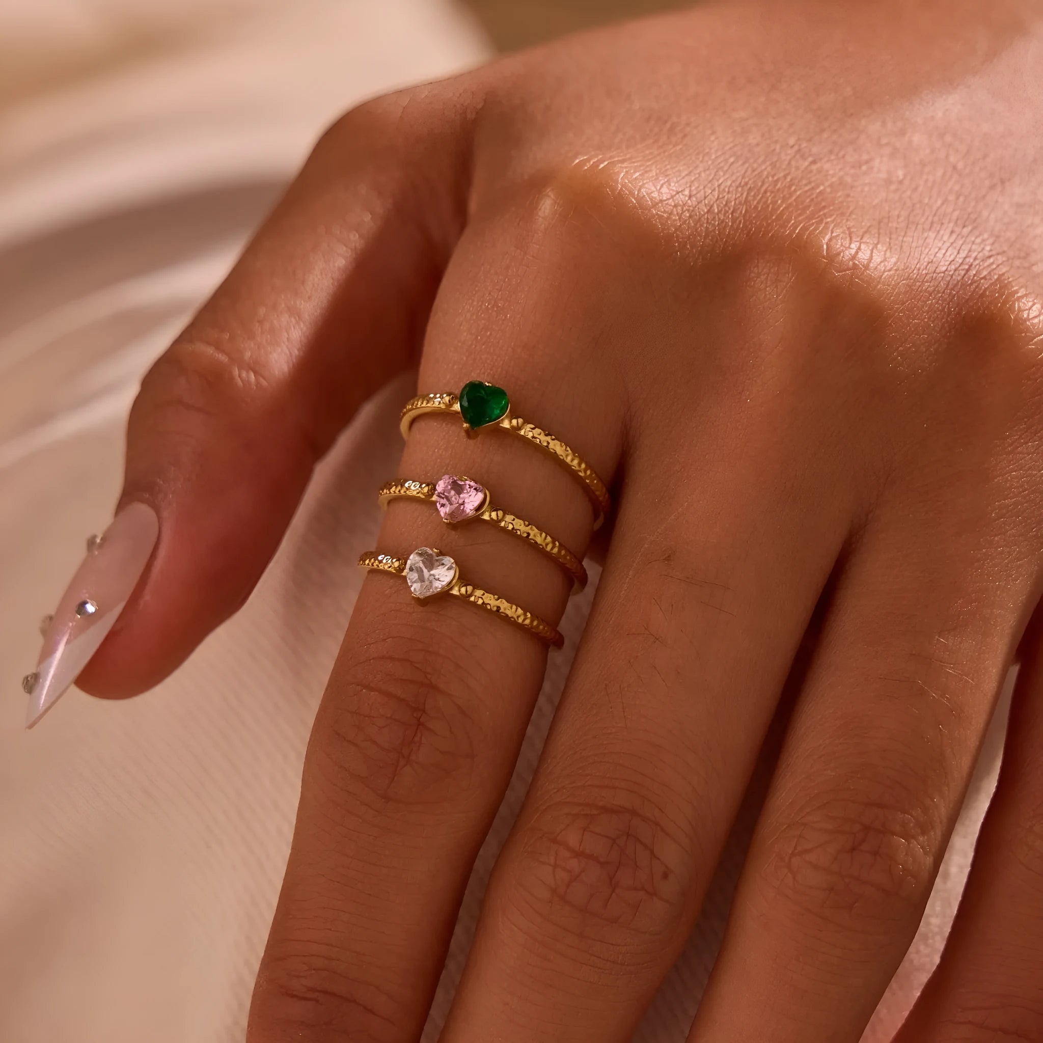 Geometric open-ended heart-shaped stainless steel ring with inlaid zircon detail in white, pink, or green.