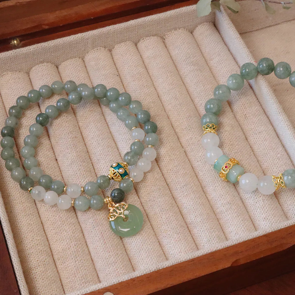Women's bracelet with a silver peace buckle pendant and green Myanmar jade beads on a black cord.