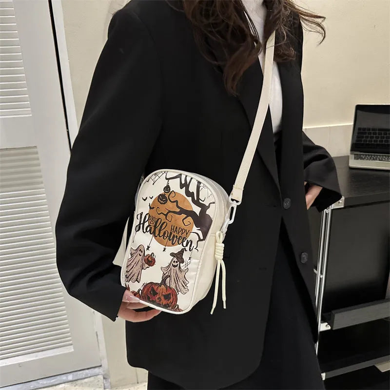 Black mini square crossbody bag with orange Halloween graffiti print of cartoon pumpkin, ghost, and bat.