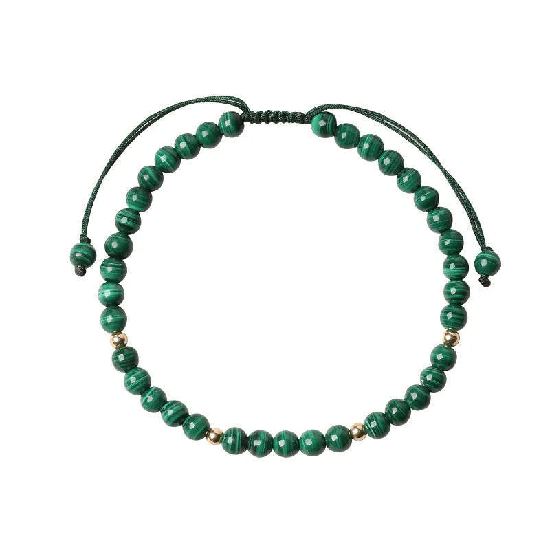 Natural green malachite crystal bracelet with golden balls on a woven hand strap.