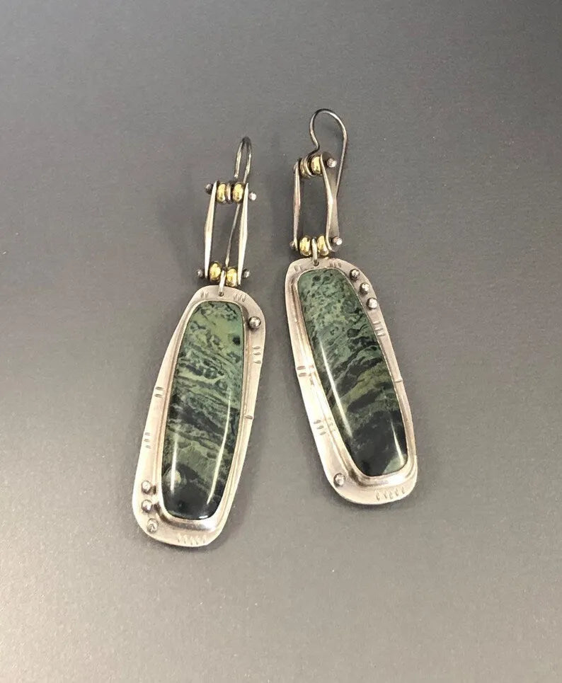 Geometric drop earrings with a white and grey marble pattern on a silver-toned alloy setting.