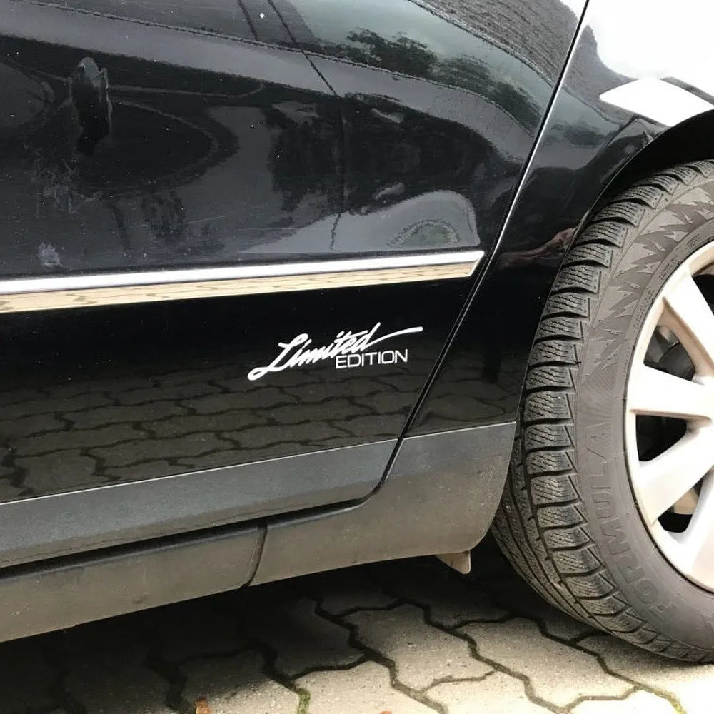 A reflective plastic bumper sticker measuring 16cm by 3.8cm, shown in black, white, and multicolour options.