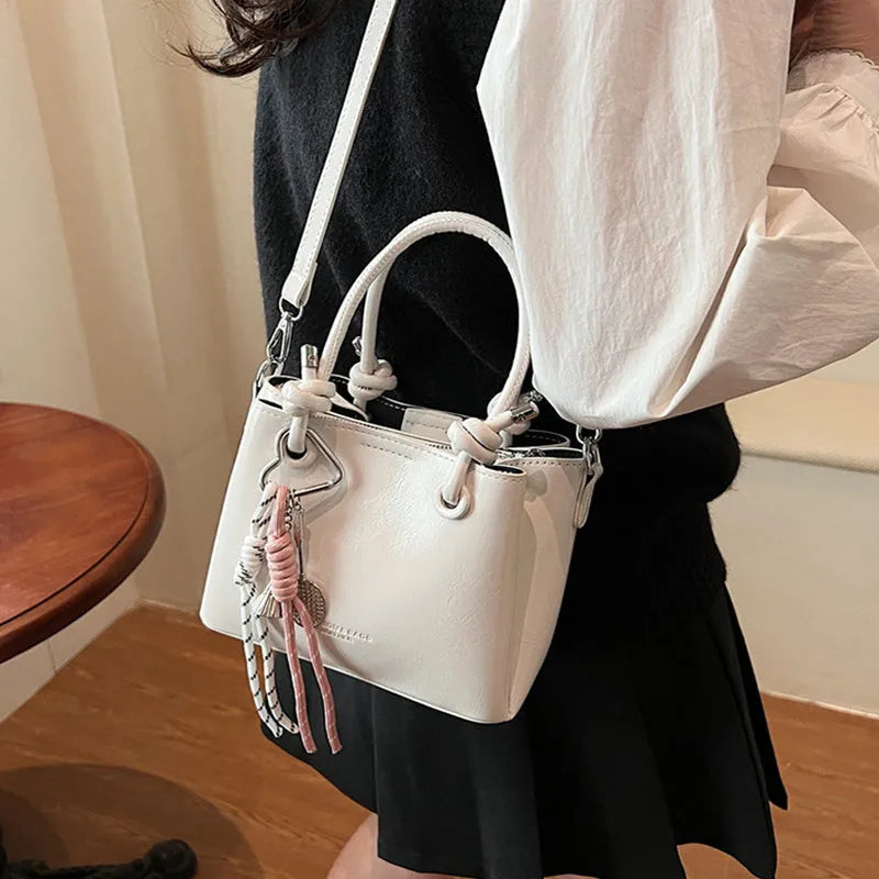 Women's medium-soft PU messenger bag in bucket shape with pendant, black, white, wine red, and pink options