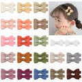 Assortment of pastel-coloured baby hair clips including barrettes and bows on a white background.