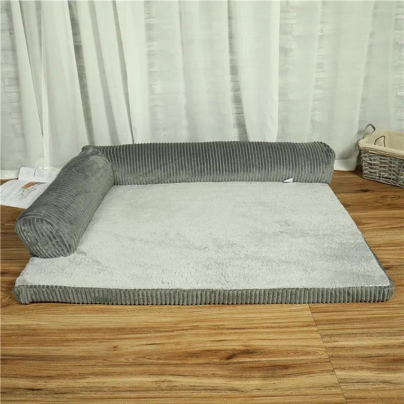 A grey corduroy bilateral-style dog sofa bed on a wooden floor