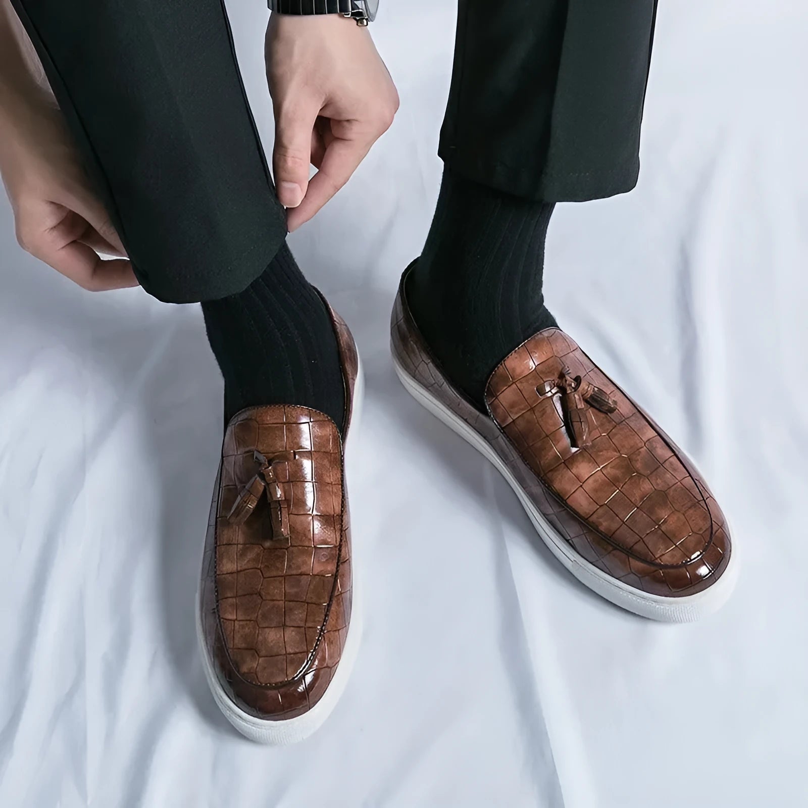 Men's brown tassel sneakers with round toe and rubber sole on a white background.
