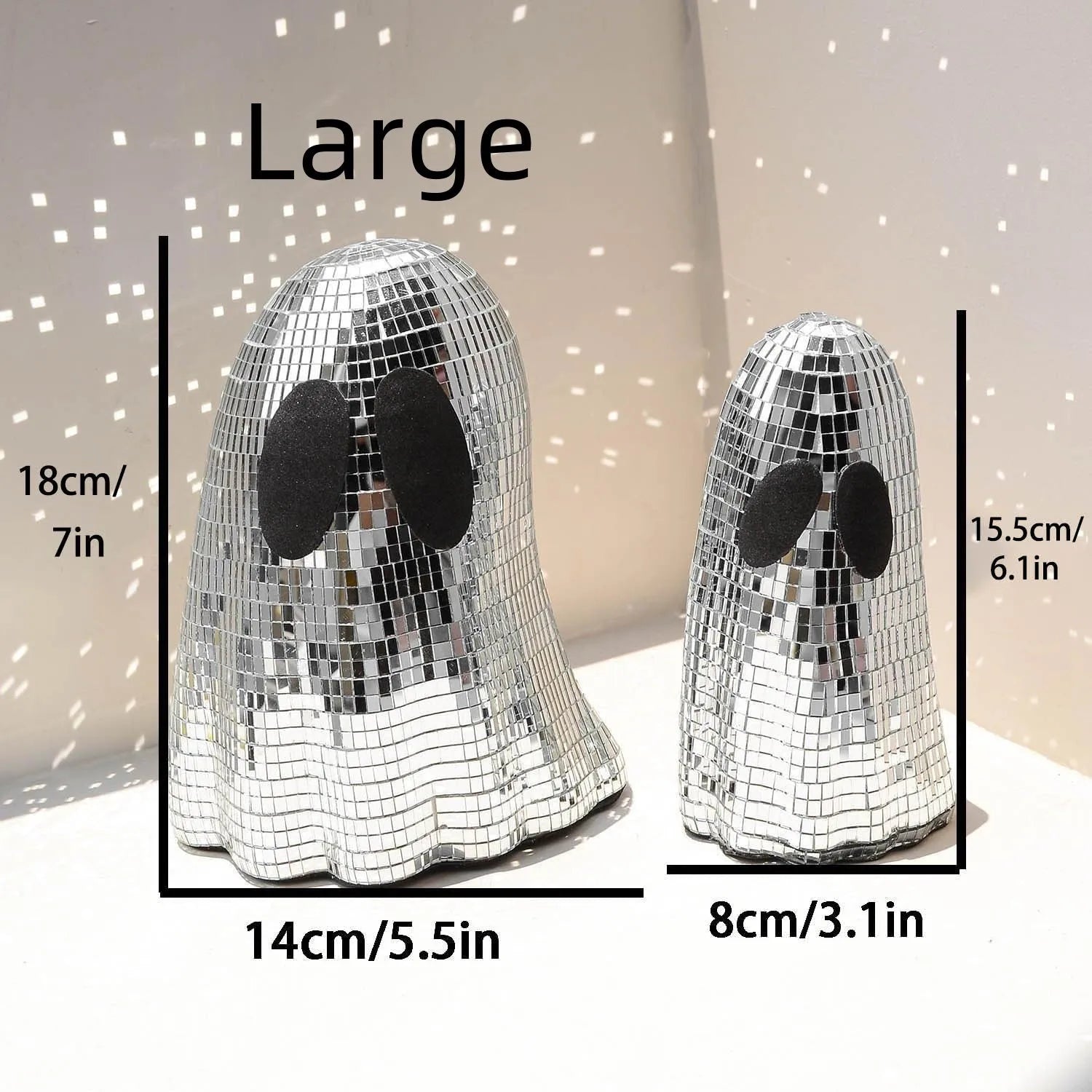 Silver glass Halloween ghost decoration with mosaic mirror patch design on a desktop.