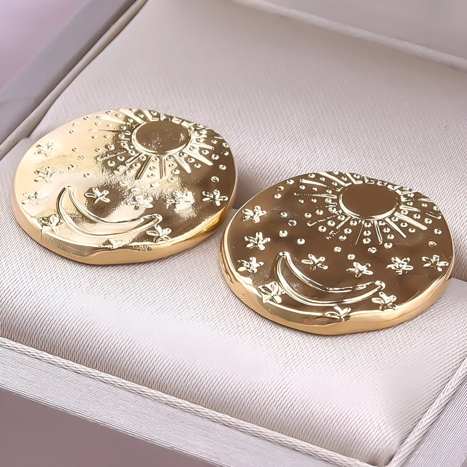 A pair of 304 stainless steel stud earrings with a geometric shape and shell detail in a gold or silver electroplated finish.