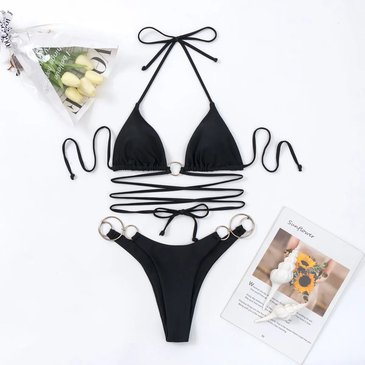 Black women's bikini set with long straps and a metal ring, shown on a model.