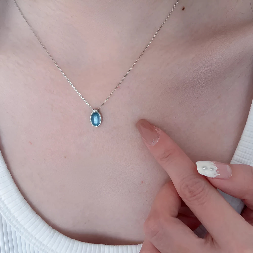 Navy blue geometric water drop pendant necklace on an adjustable cross chain.
