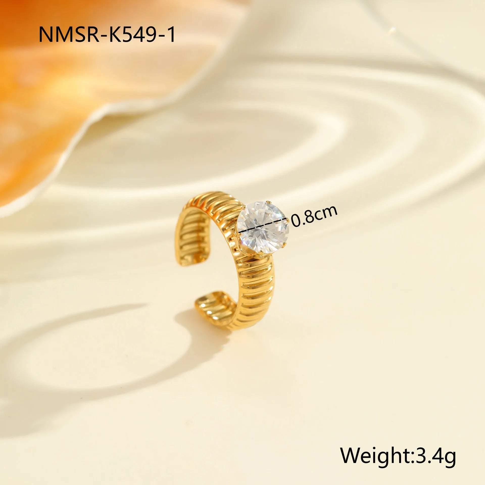 Gold electroplated adjustable ring with geometric zircon design on a stainless steel band.
