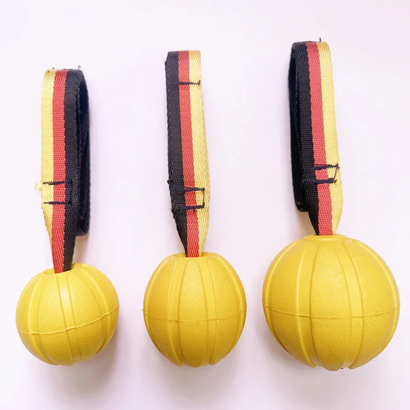 Yellow EVA floating tetherball for dog water training next to a camouflage-coloured ball.