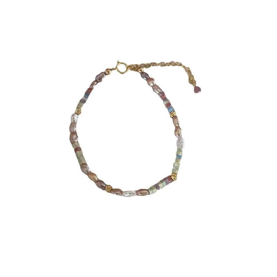 A women's bracelet and necklace set with irregular natural pearls and a 14K gilded purple finish.